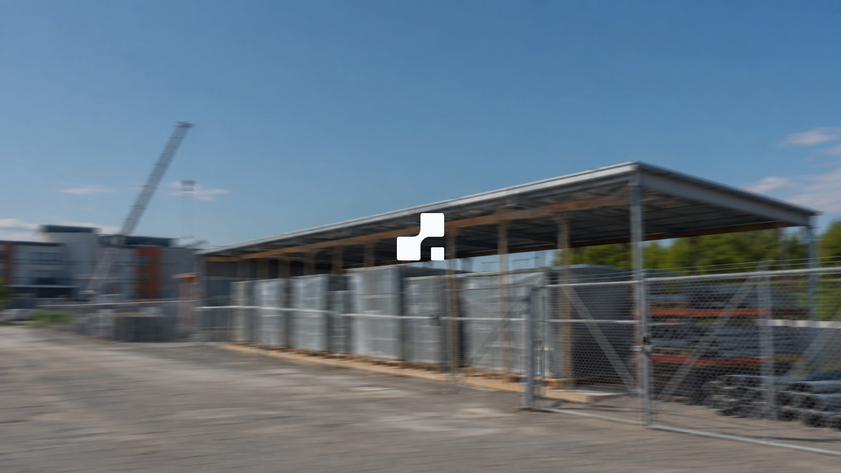 Motion-blurred summer view of protected electrical materials beside a Canadian institutional construction project, overlaid with the Aplon mark