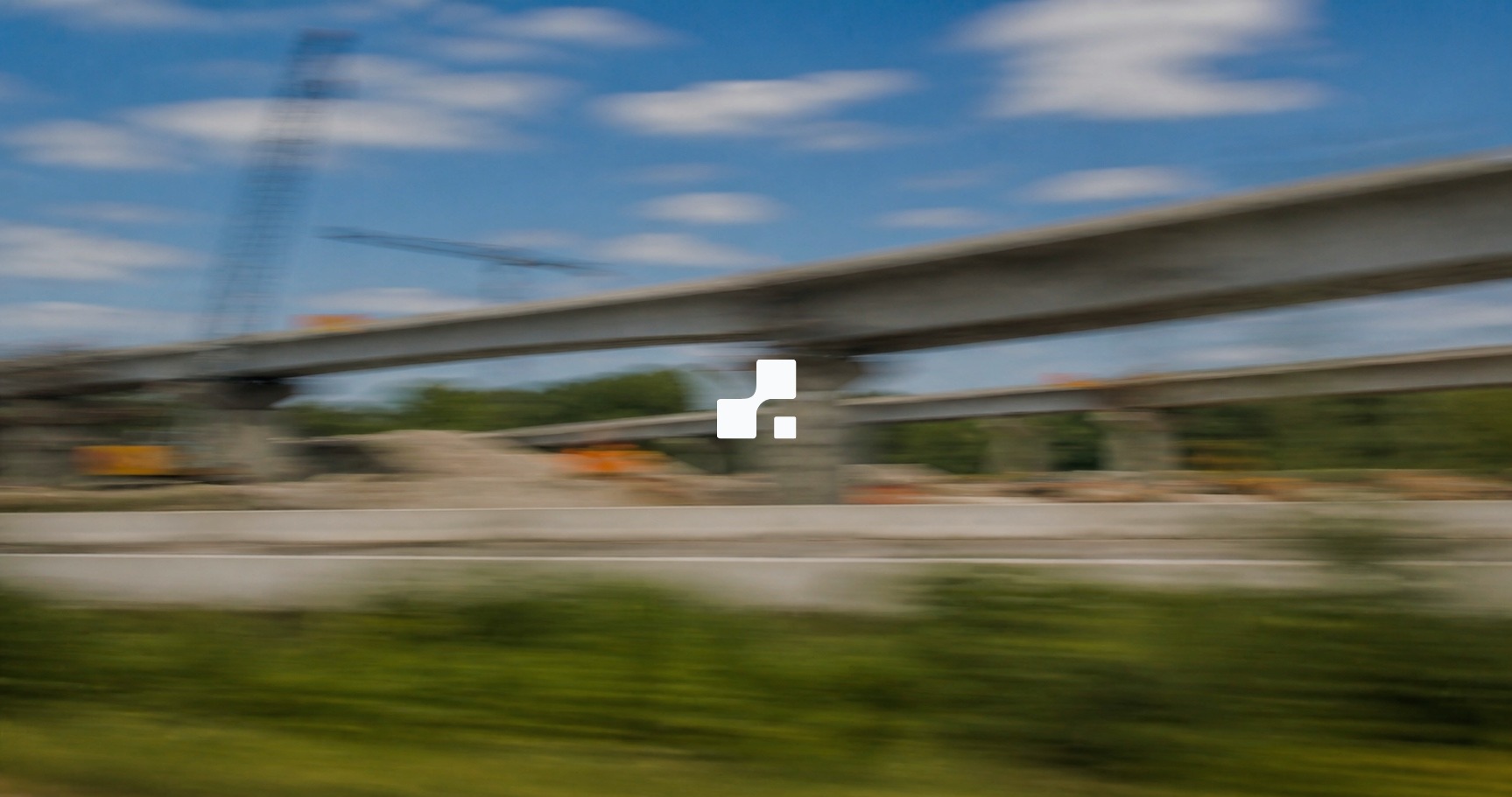 Motion-blurred summer view of a highway interchange under construction, overlaid with the Aplon mark